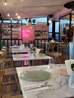 an empty restaurant with tables and chairs in front of large windows that read welcome diners