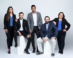 three men and two women are posing for a photo in front of a white background