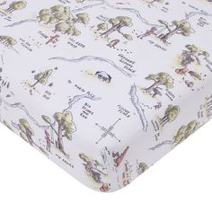 a white crib sheet with trees and animals printed on the top, along with words written in english