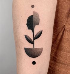 a woman's arm with a black and white flower tattoo on the left forearm