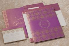 the wedding stationery is purple and gold, with an embossed monogram