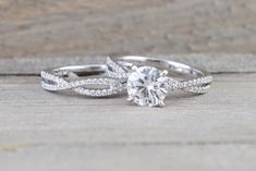 a white gold engagement ring with a twisted band and a round brilliant cut diamond in the center