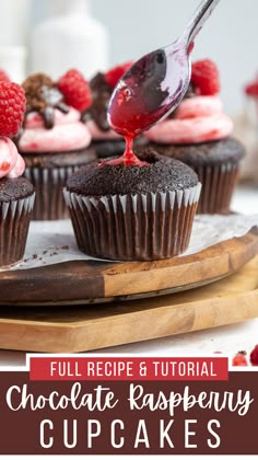 chocolate raspberry cupcakes on a cutting board with raspberries in the background