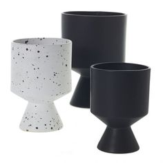 three black and white vases sitting next to each other