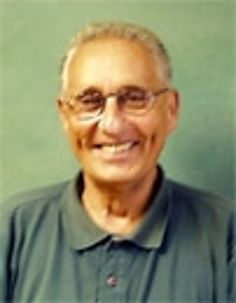 an older man with glasses smiling for the camera