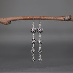 "Four gorgeous and detailed graduated Bali Silver beads are wire wrapped to create these gorgeous statement earrings. These dangle from balled silver earwires. Perfect dramatic earrings for anyone to wear everyday or save for a special occasion. First Bali Silver bead: 8mm Second Bali Silver bead: 7mm Third Bali Silver bead: 6mm Fourth Bali Silver bead: 5mm Total length of earrings: 2 3/8\" All silver is sterling. As the owner, maker, designer, and curator of this shop, I take great pride in pro Elegant Nickel-free Chandelier Earrings With Round Beads, Sterling Silver Beaded Earrings For Jewelry Making, Dangling Beads Drop Earrings, Sterling Silver Earrings With Dangling Beads, Elegant Sterling Silver Nickel-free Beaded Earrings, Elegant Sterling Silver Beaded Earrings Nickel Free, Elegant Handmade Sterling Silver Beaded Earrings, Elegant Nickel-free Beaded Sterling Silver Earrings, Elegant Nickel-free Sterling Silver Beaded Earrings