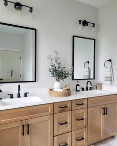 a bathroom with double sinks and mirrors on the wall