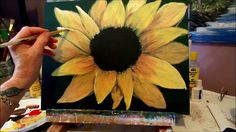 a person is painting a sunflower with acrylic paint