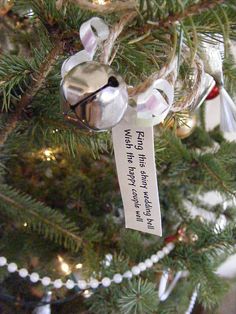 an ornament hanging from the top of a christmas tree with a message on it