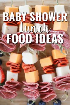 baby shower lunch idea with ham, cheese and blueberries on skewers that are ready to be eaten