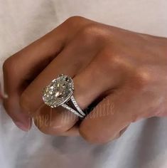 a woman's hand with a diamond ring on it