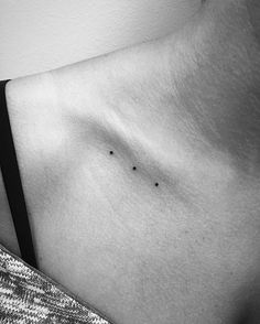 a black and white photo of a woman's chest with tiny dots on it