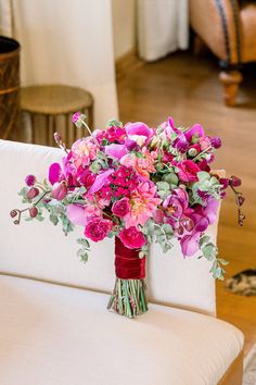 a bouquet of pink flowers sitting on top of a white couch