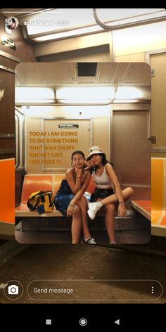 two women sitting on a bench in a train