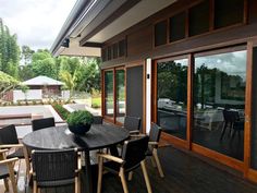 a table and chairs on a wooden deck with sliding glass doors to the back yard