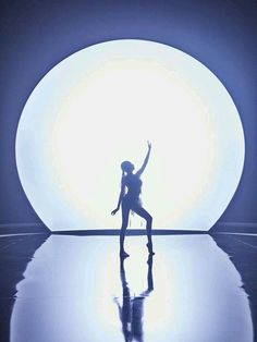 a person standing in front of a large white ball on top of a dance floor