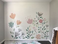 a room with flowers painted on the wall and plates laid out in front of it