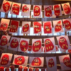 red and yellow art work hanging from the ceiling with paper cut outs attached to them