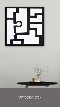 a black and white painting on the wall above a table