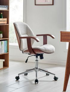 an office chair sitting on top of a wooden desk next to a book shelf and bookshelf