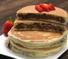 stack of pancakes topped with chocolate and strawberries