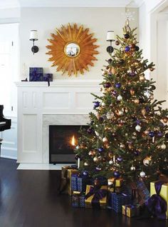 a decorated christmas tree in front of a fireplace