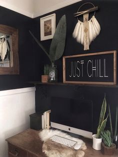 a desk with a computer on it and some plants in front of the monitor that says just chill