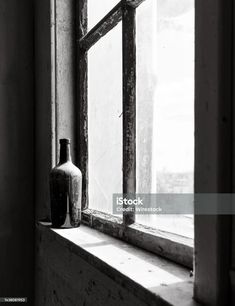 black and white photograph of an old window sill with a bottle on the ledge