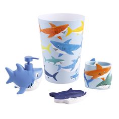 three cups with shark designs on them and one cup in the shape of a toothbrush holder