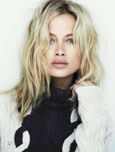 a black and white photo of a woman with long blonde hair wearing a turtle neck sweater