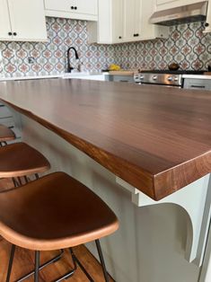 three stools sit at the edge of a kitchen counter