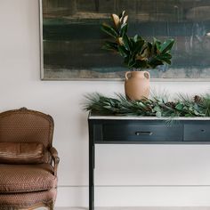 a table with a potted plant sitting on top of it next to a chair