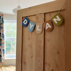 a bed room with a wooden headboard and some letters hanging from the clothes line