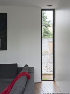 a grey couch sitting next to a window in a living room