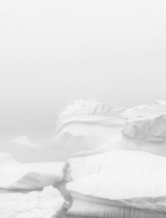 a polar bear standing on top of an iceberg in the snow and looking at something