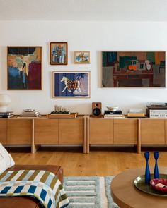 a living room filled with furniture and pictures on the wall above it's coffee table