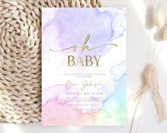 a watercolor baby shower with gold foil lettering on the front and back of it