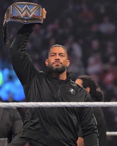 a man holding up a wrestling belt in the air