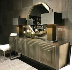 a large mirror sitting on top of a wooden cabinet next to a table with candles