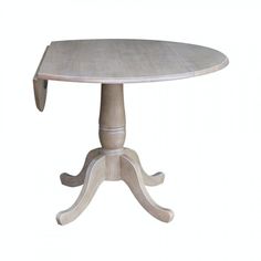 a wooden table with an oval shaped top and two leaves on the base, sitting on a white background