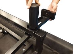 a hand is holding the handle on a conveyor belt that's attached to a machine