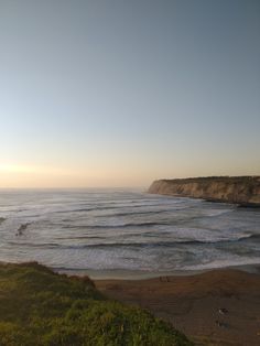 an ocean view with waves crashing on the shore