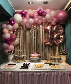 a table topped with lots of desserts and balloons