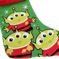 two green monsters are standing next to each other in front of a christmas stocking