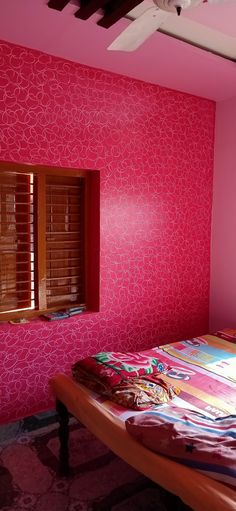 a bed room with a neatly made bed and pink walls