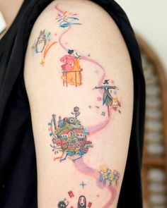 a woman's arm with colorful tattoos on it and an airplane in the sky