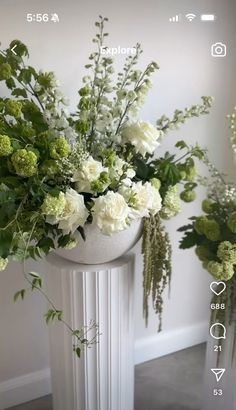 two vases filled with white and green flowers