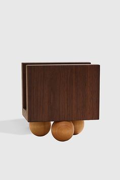 two wooden balls are in the middle of a box with one ball on it's side