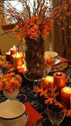 the table is set with orange flowers and candles