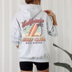 California Surf Club Hoodie, the perfect beachy sweatshirt for surf enthusiasts and coconut girls alike. This summer hoodie captures the essence of California's surf culture with its laid-back style and vibrant design. Made with high-quality materials, this surf hoodie is not only stylish but also comfortable, making it ideal for those breezy beach days or cozy nights by the bonfire. Channel your inner surfer with the California Surf Club Hoodie and embrace the carefree spirit of the California coast. 🖤 For oversized order 1-3 sizes up, refer to listing photos for sizes. RUNS ON THE SMALLER SIDE 🖤 Gildan 18500 🖤 Some Shrinkage may occur with washing 🖤 This unisex heavy blend hooded sweatshirt is relaxation itself.  🖤 Made with a thick blend of cotton and polyester, it feels plush, sof Sporty Cotton Hoodie For Beach, Casual Hoodie For Beach Season Loungewear, Casual Surfing Hoodie Sweatshirt, Casual Surfing Hoodie With Graphic Print, Casual Letter Print Hoodie For Beachwear, Sporty Long Sleeve Beach Hoodie, Sporty Beach Hoodie With Letter Print, Long Sleeve Hoodie With Letter Print For Surfing, Hooded Sweatshirt With Letter Print For Surfing